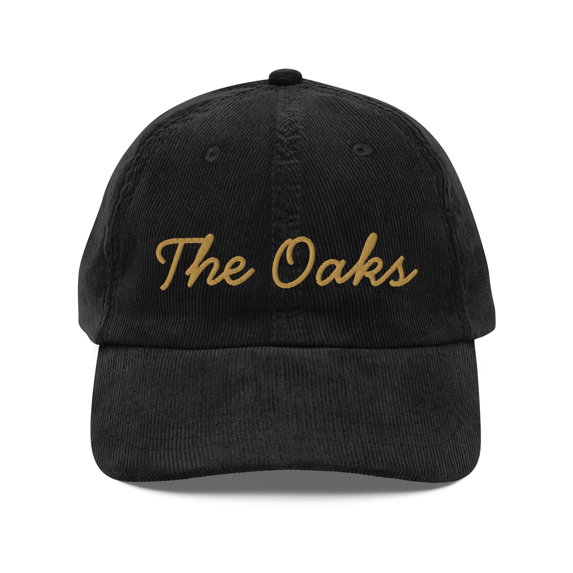 Product mockup: An black colored corduroy cap on a white background featuring gold lettering in a handwriting font that says "The Oaks"