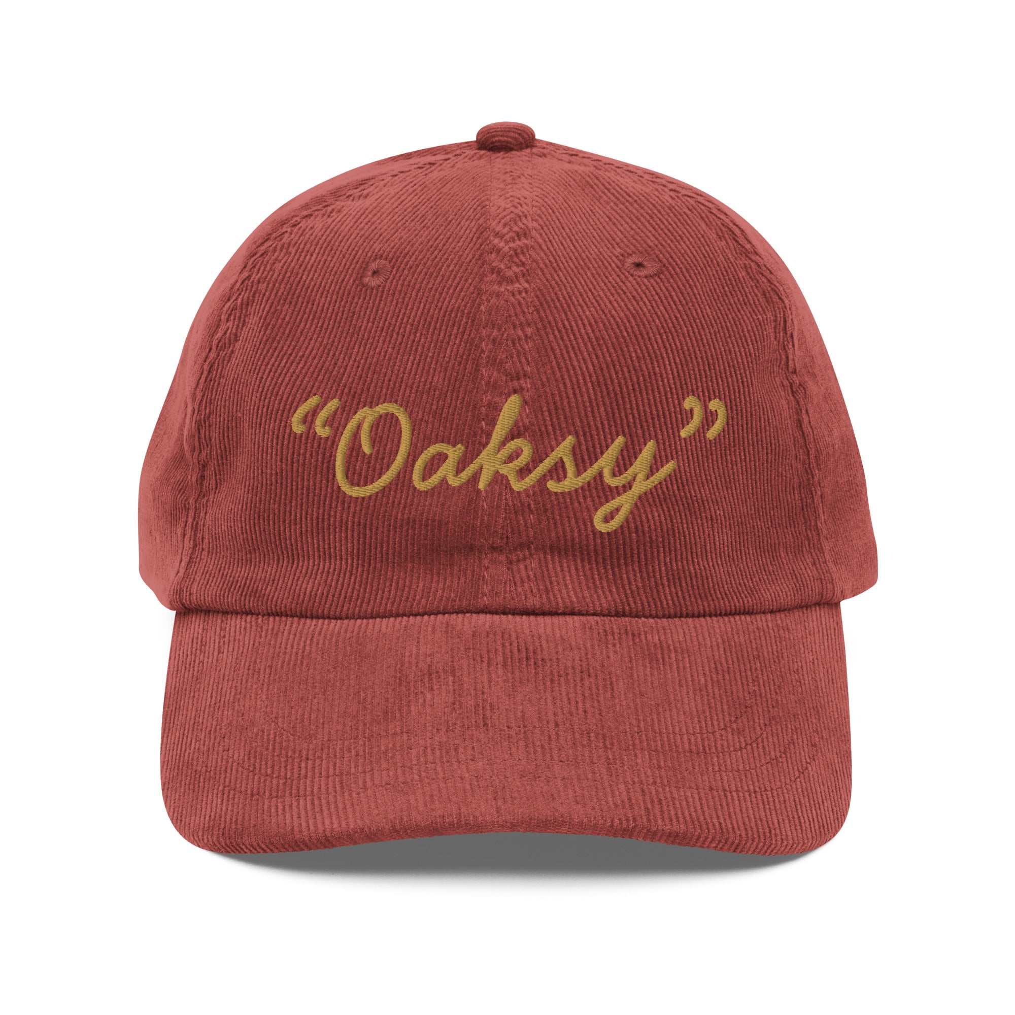 Product mockup:  A burgundy corduroy cap on a white background featuring gold lettering in a handwriting font that says "Oaksy" in quotes