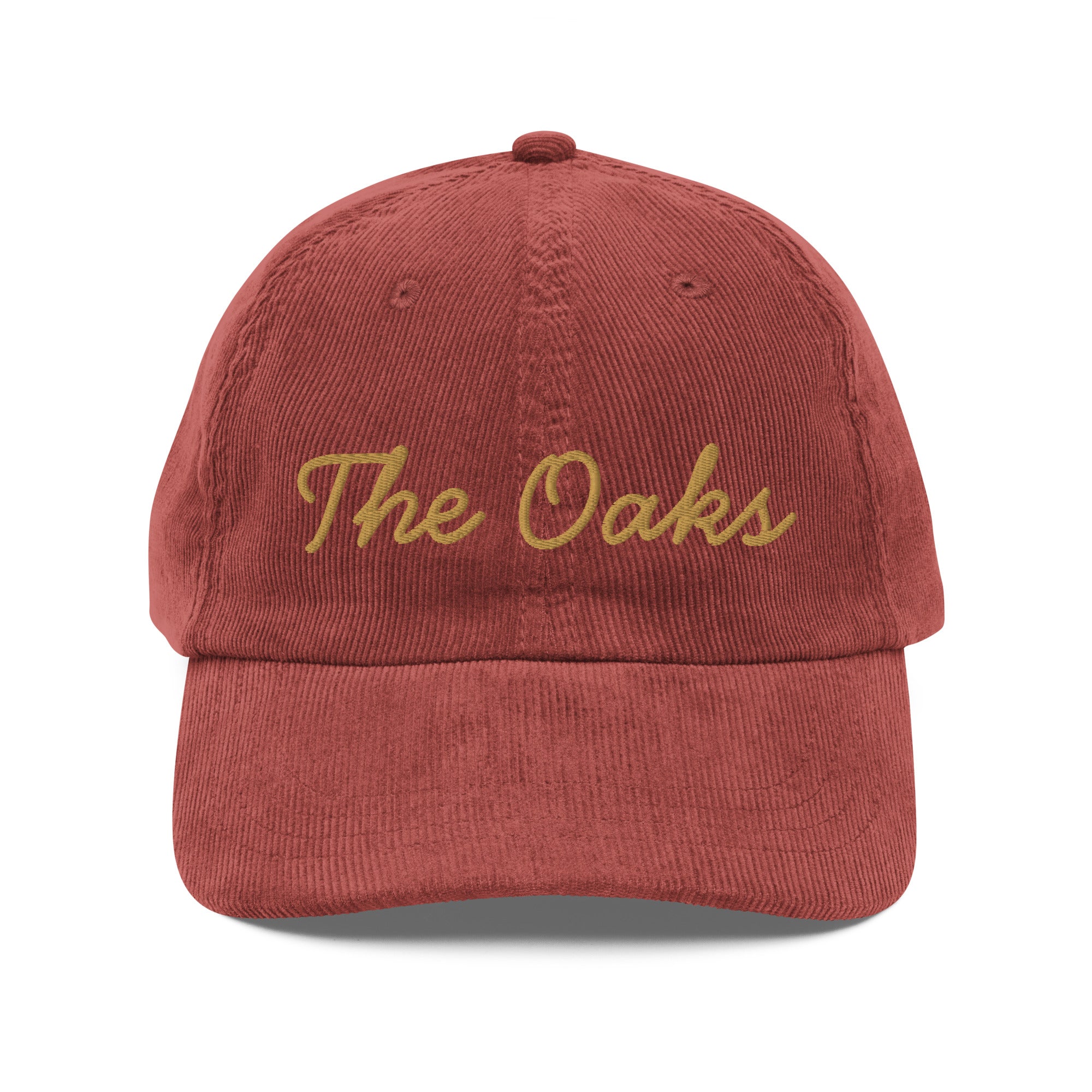 Product mockup: An burgundy colored corduroy cap on a white background featuring gold lettering in a handwriting font that says "The Oaks"
