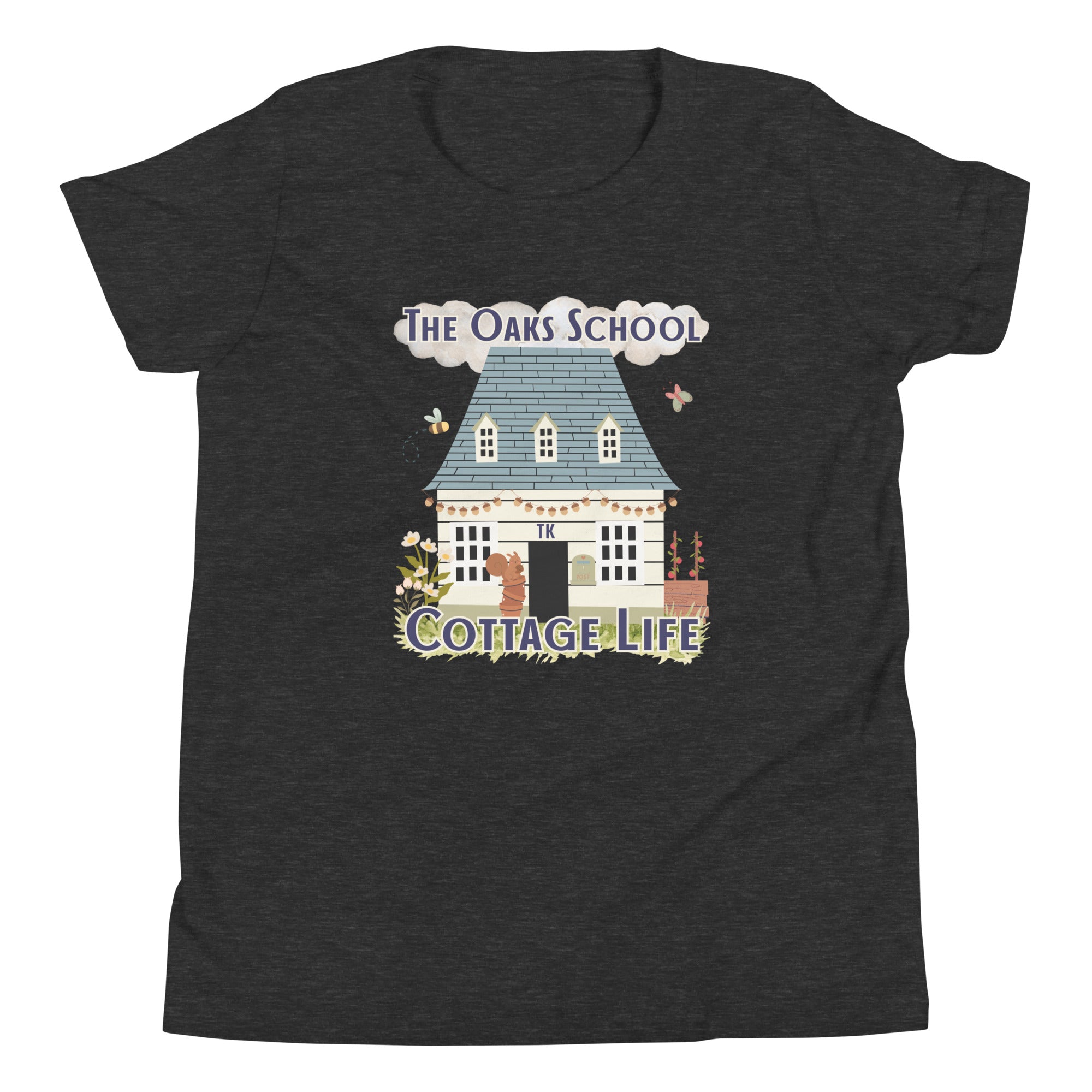 Product mockup: A dark gray heather colored tshirt on a white background featuring an illustration of a white cottage and the text "The Oaks School" and "Cottage Life"