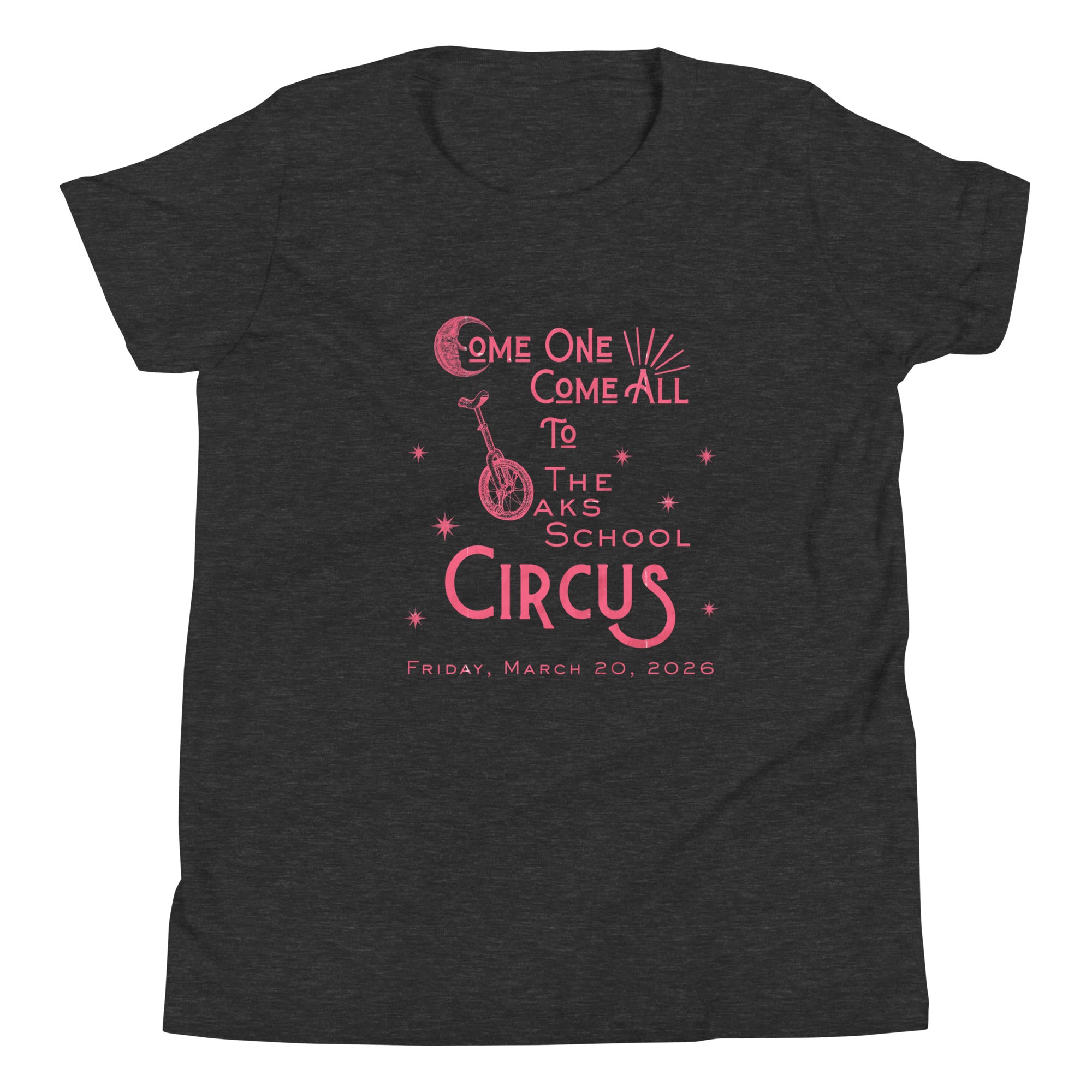 Product mockup: Dark grey heather tee with pink, weathered text "Come one, Call All to The Oaks School Circus, Friday, March 20, 2026." The "O" in "Oaks" is a unicycle wheel, the "C" in the first "Come" is a crescent moon, and there are stars sprinkled throughout.