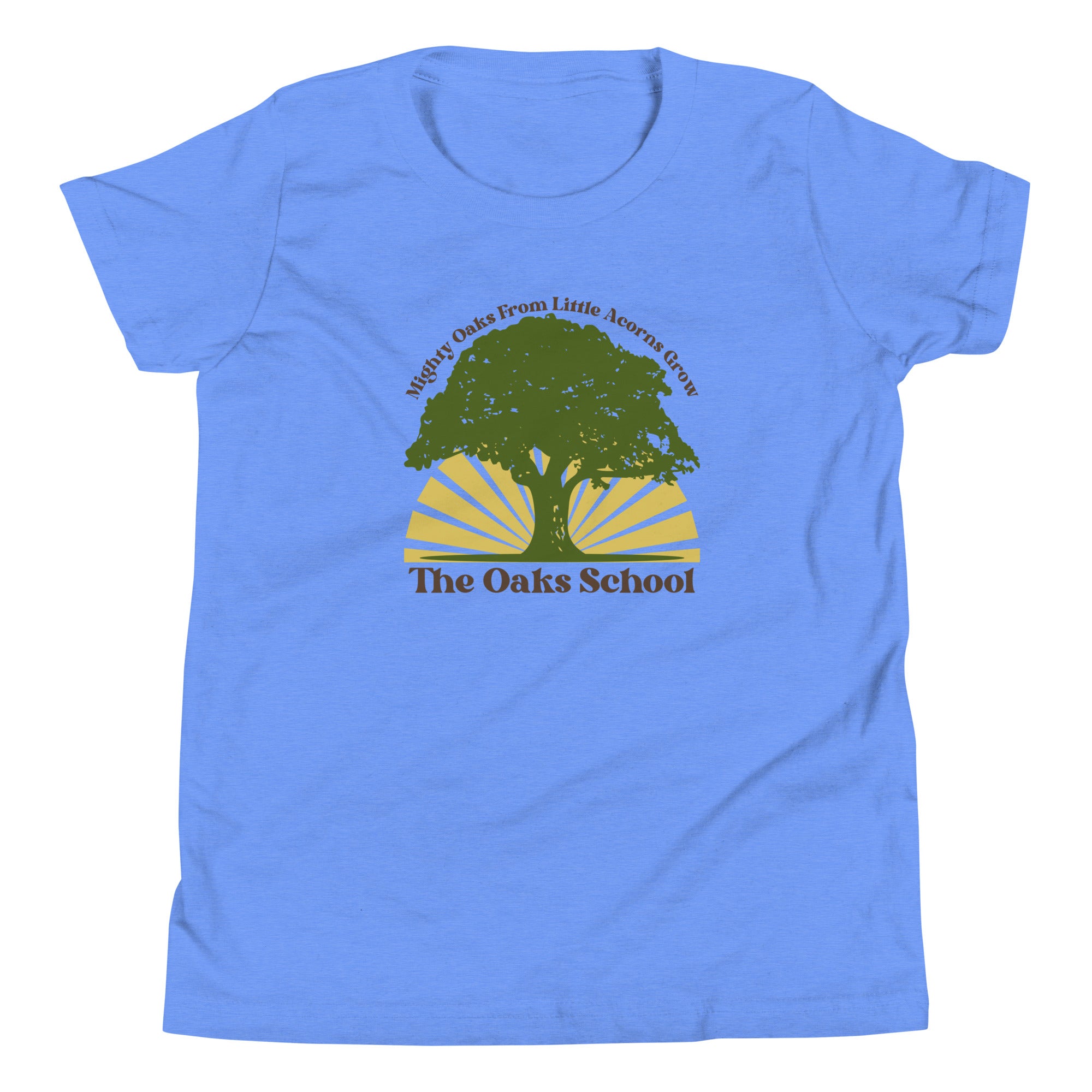 Product mockup: A bright blue tshirt on a white background featuring a green oak tree illustration on a yellow sunburst with text that says "Mighty Oaks from Little Acorns Grow" and "The Oaks School"