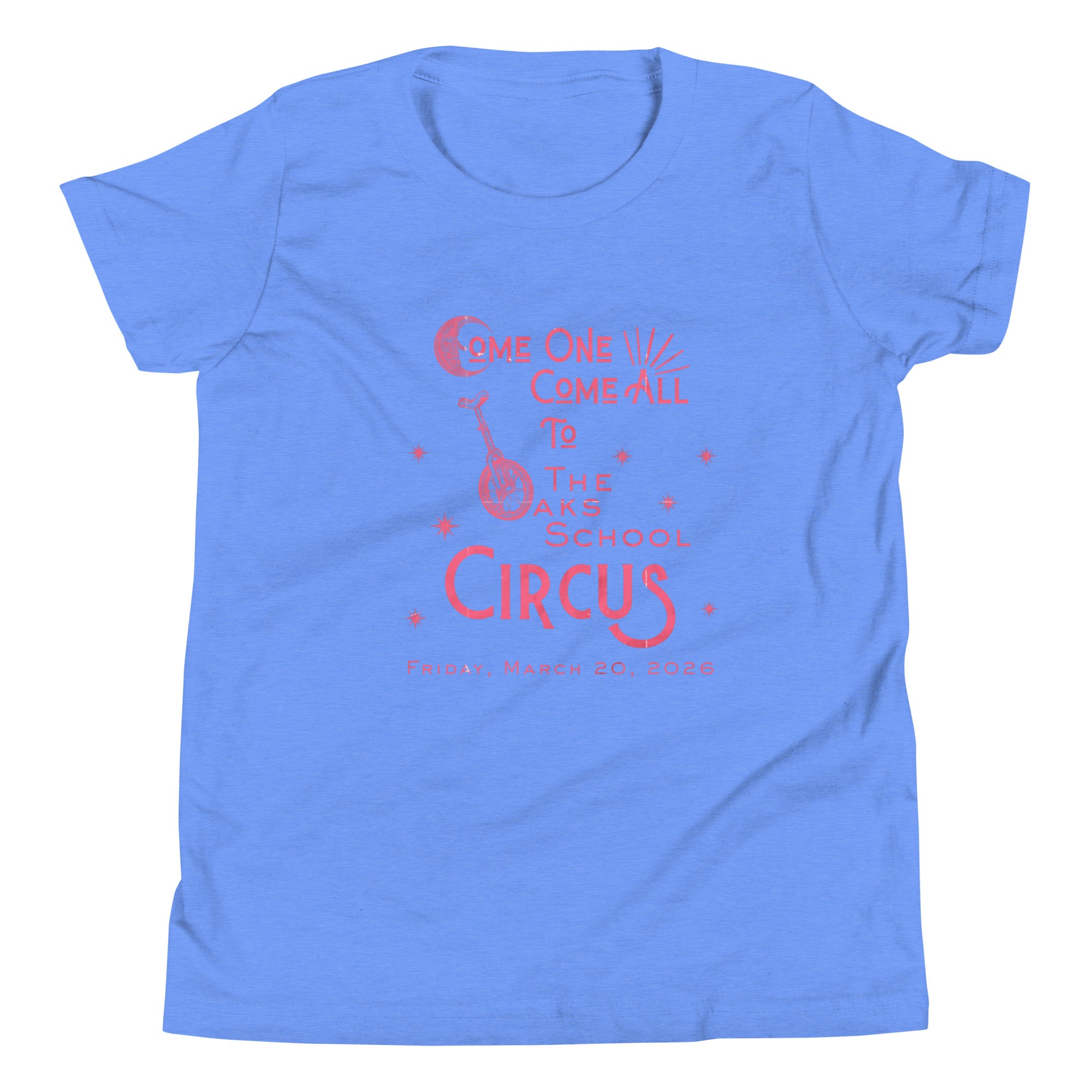 Product mockup: Columbia blue heathered tee with pink, weathered text "Come one, Call All to The Oaks School Circus, Friday, March 20, 2026." The "O" in "Oaks" is a unicycle wheel, the "C" in the first "Come" is a crescent moon, and there are stars sprinkled throughout.