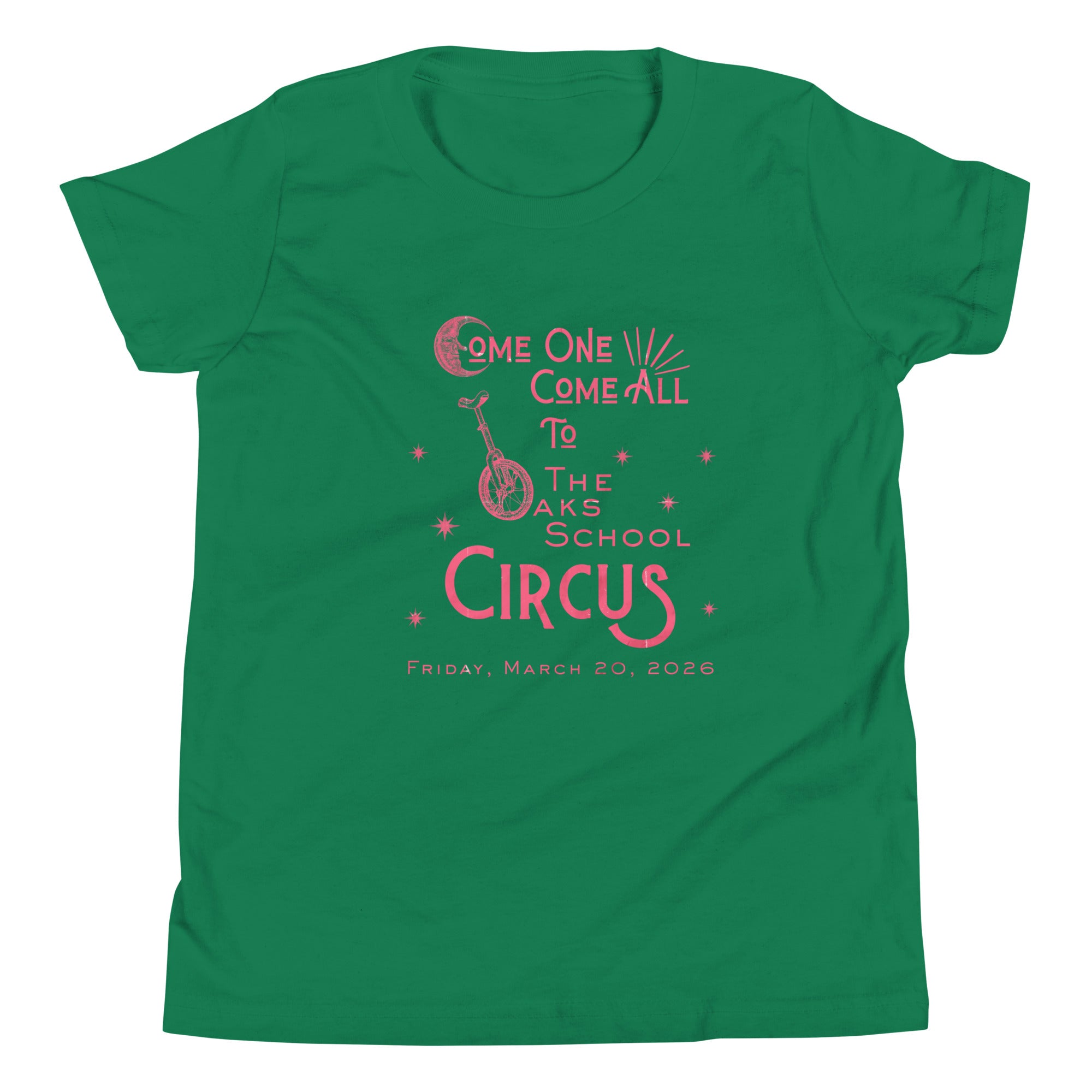 Product mockup: Kelly green tee with pink, weathered text "Come one, Call All to The Oaks School Circus, Friday, March 20, 2026." The "O" in "Oaks" is a unicycle wheel, the "C" in the first "Come" is a crescent moon, and there are stars sprinkled throughout.