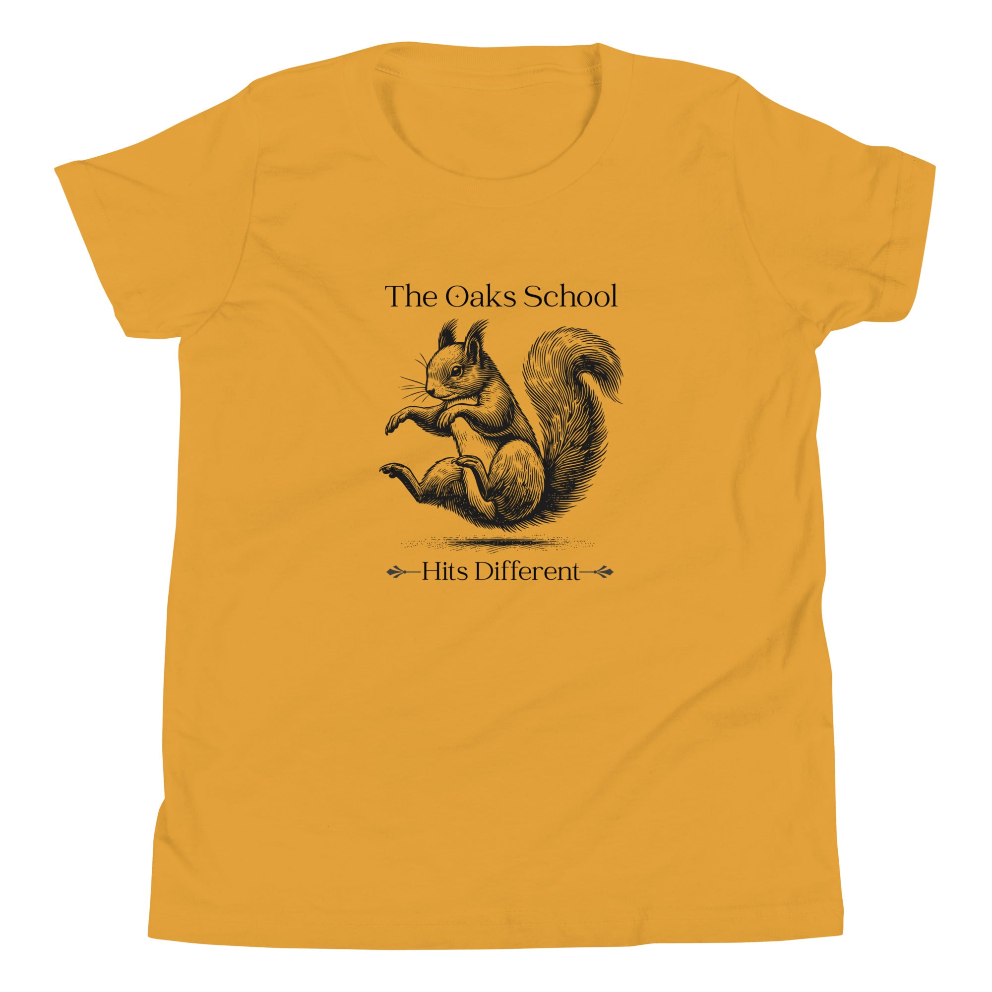 Product mockup: A mustard yellow tshirt on a white background featuring an illustration of a squirrel landing on its bottom and the text "The Oaks School" and "Hits Different"
