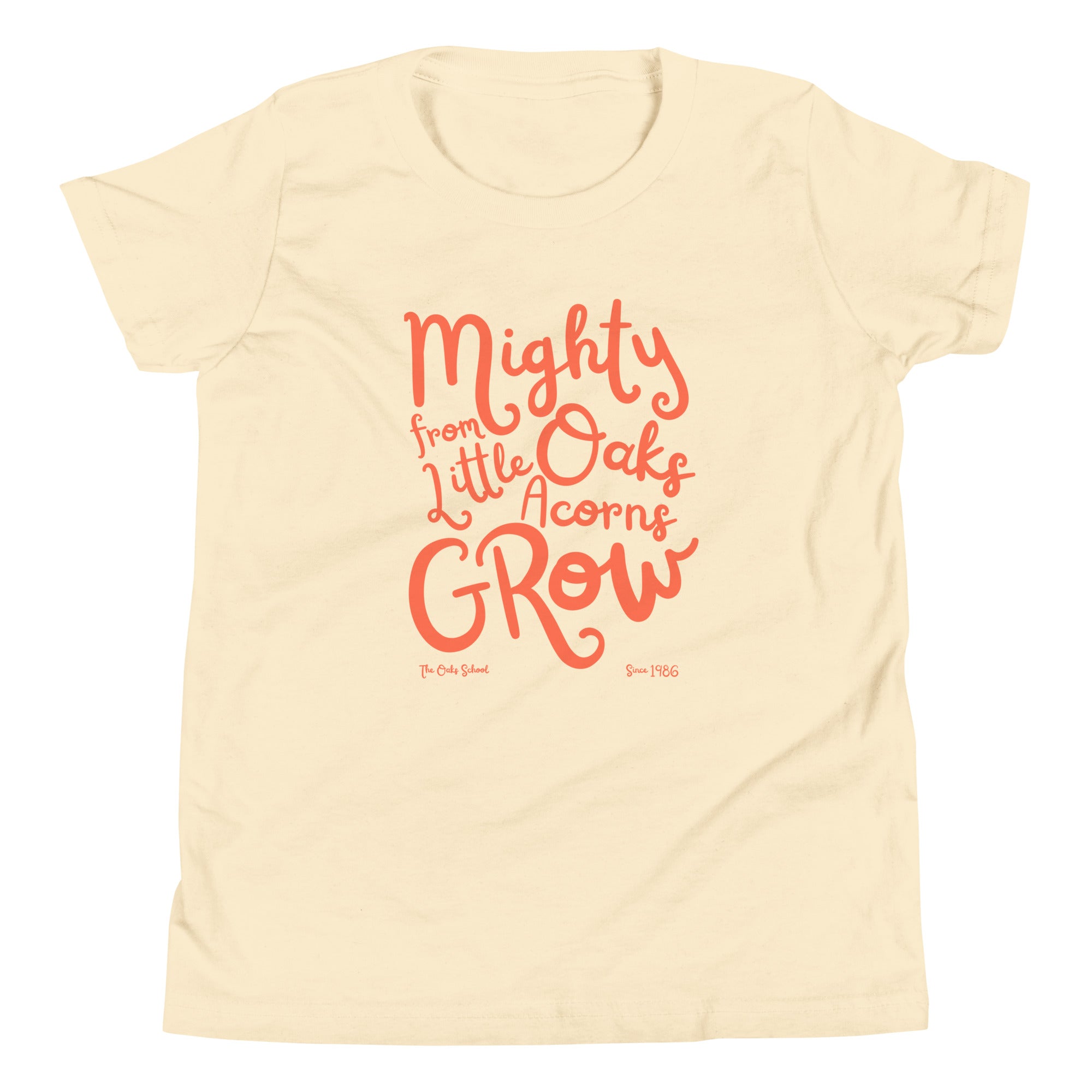 Product mockup: A natural colored tshirt on a white background with orange script text that says "Mighty Oaks from Little Acorns Grow" and "The Oaks School Since 1986"