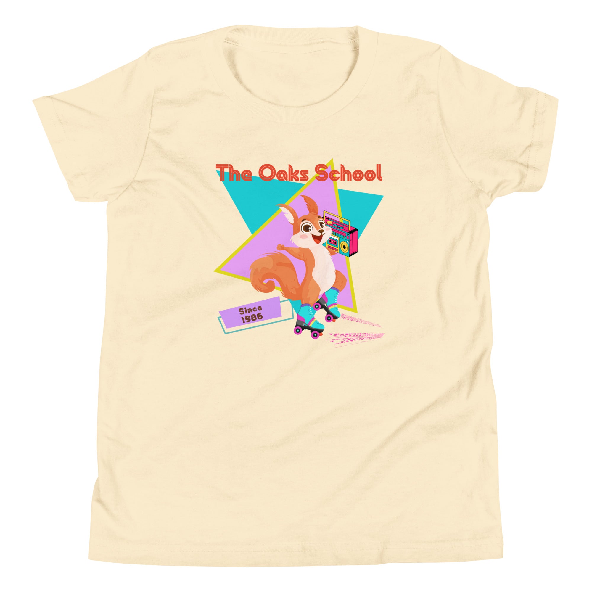 Product mockup: Natural colored tshirt on white background featuring a squirrel with roller skates holding a boombox and text that reads "The Oaks School" and "Since 1986"