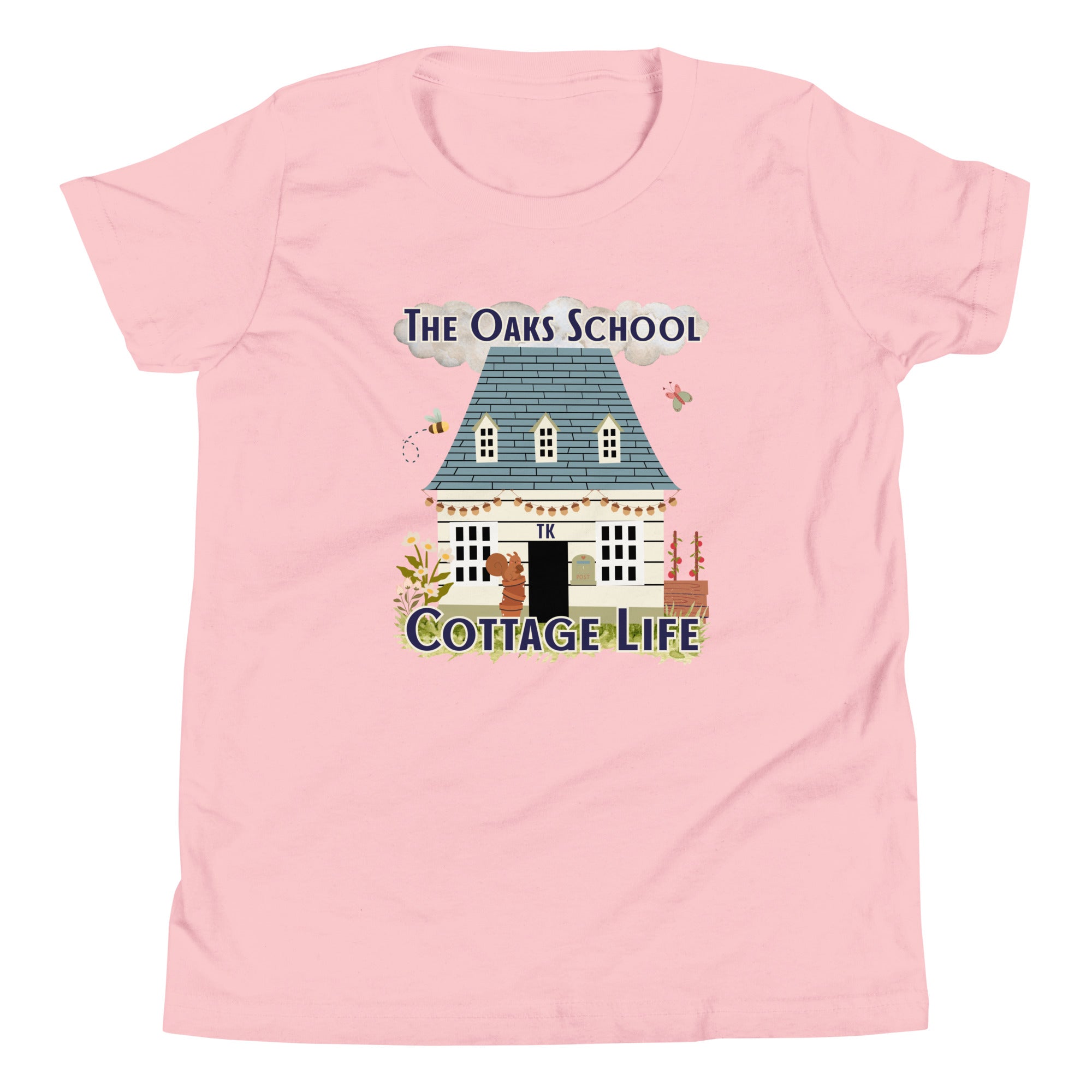 Product mockup: A pink tshirt on a white background featuring an illustration of a white cottage and the text "The Oaks School" and "Cottage Life"