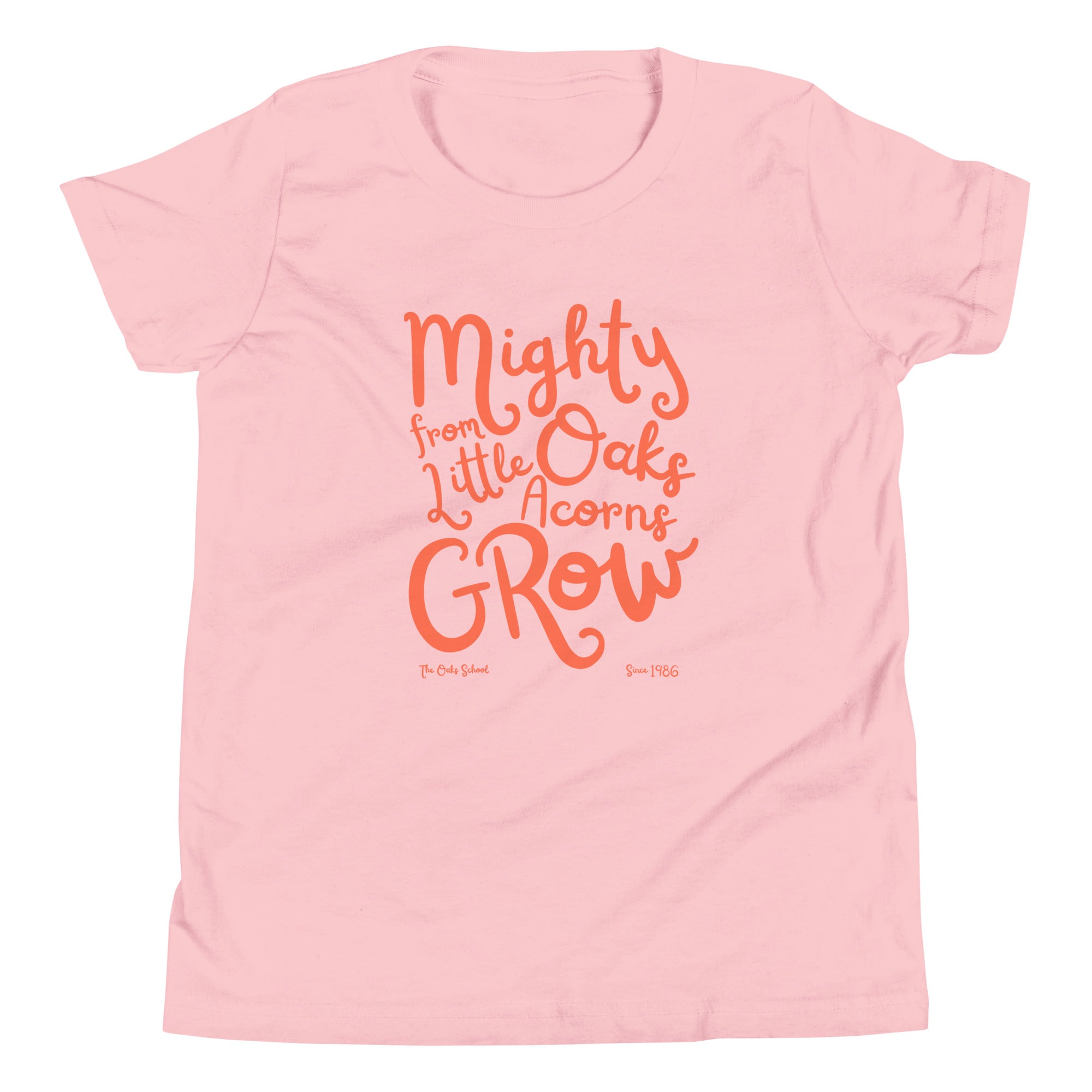 Product mockup: A pink tshirt on a white background with orange script text that says "Mighty Oaks from Little Acorns Grow" and "The Oaks School Since 1986"