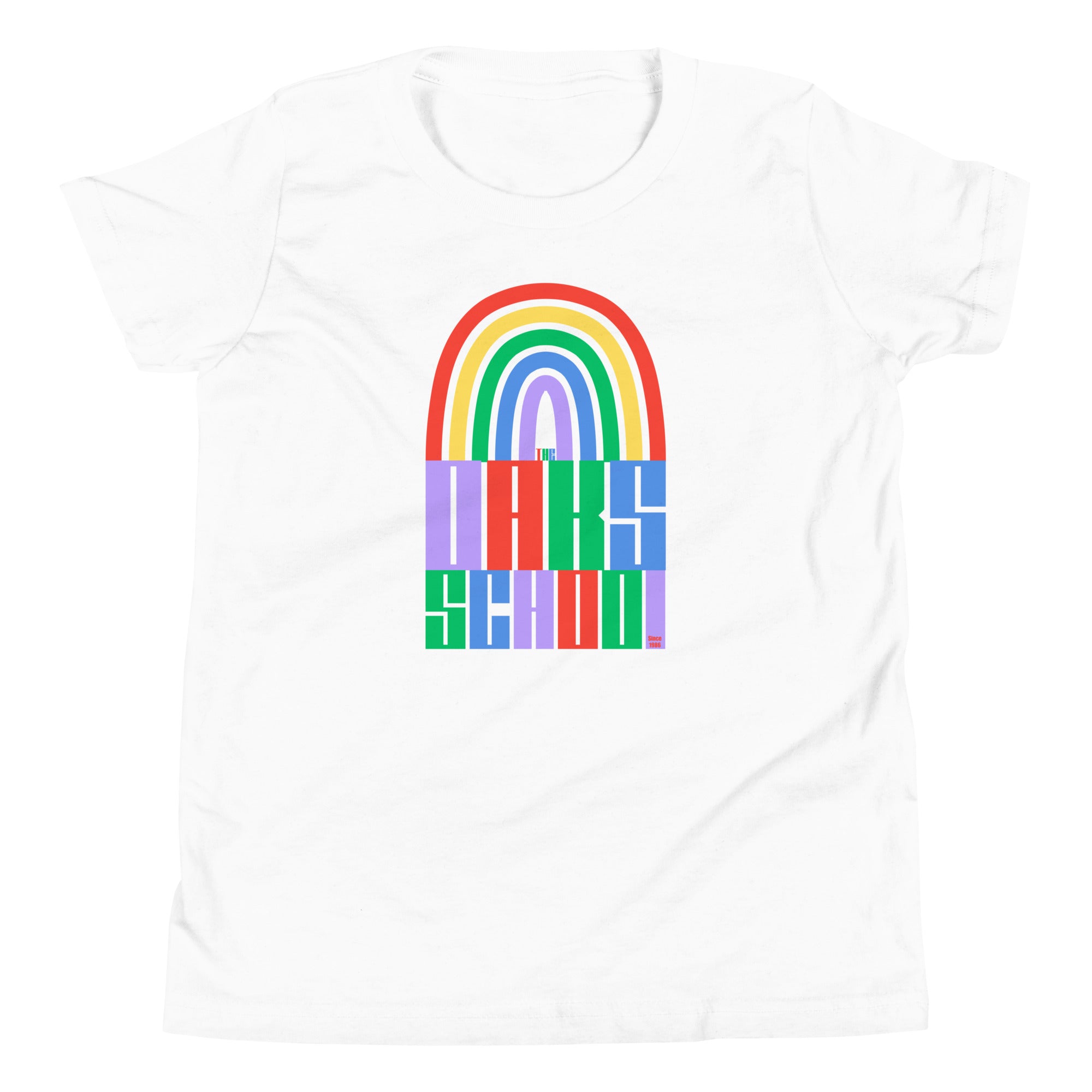 Product mockup: A white tshirt on a white background featuring a rainbow illustration flowing into rainbow colored block letters that say "The Oaks School"