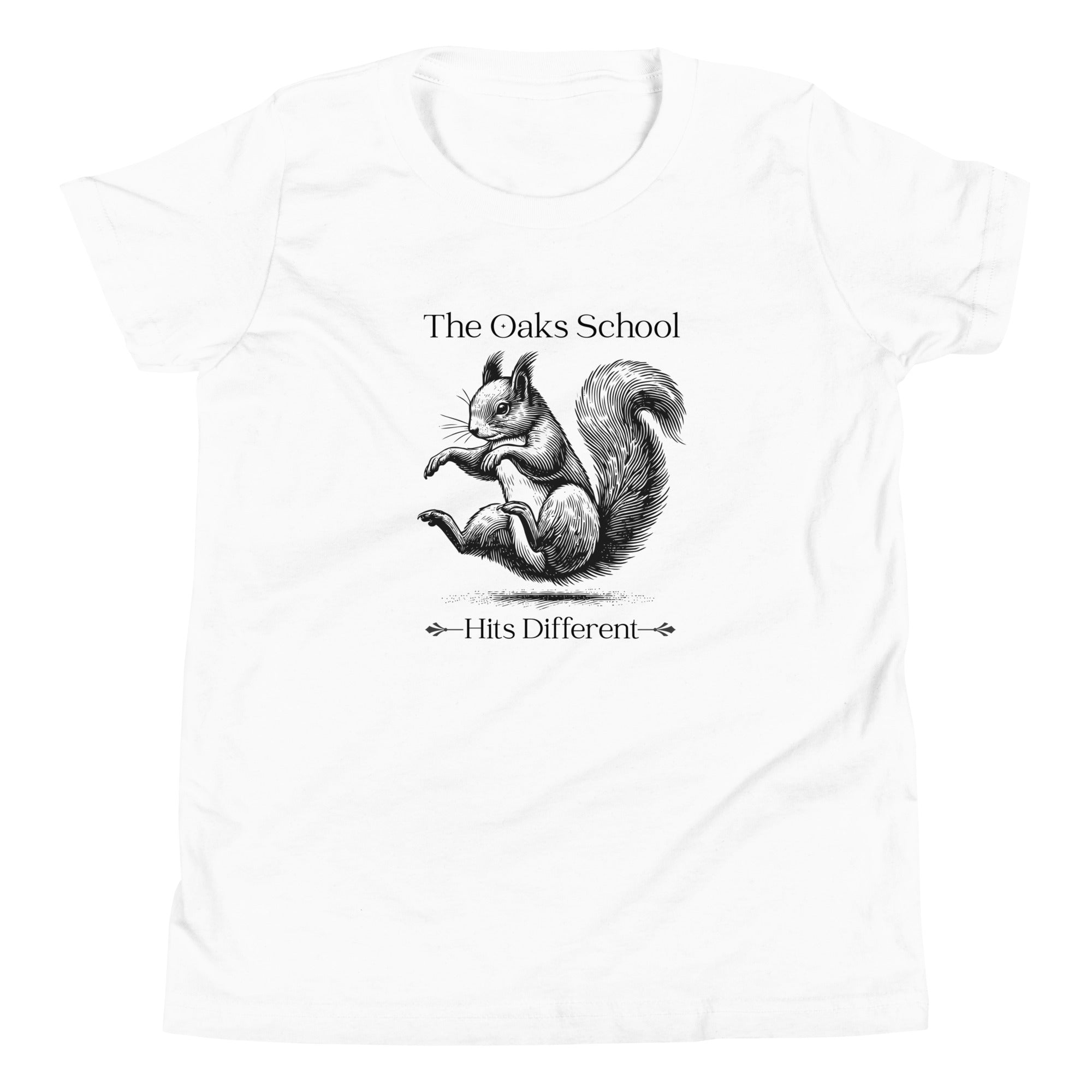 Product mockup: A white tshirt on a white background featuring an illustration of a squirrel landing on its bottom and the text "The Oaks School" and "Hits Different"